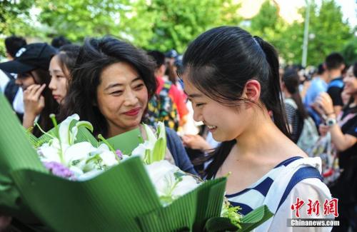 資料圖：山東濟南眾多考生手捧鮮花在家長的簇擁下歡快告別高考。中新社記者 張勇 攝