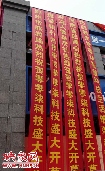 路邊一棟樓上懸掛著二三十條紅色條幅，全部是祝賀一家公司開業(yè)的。