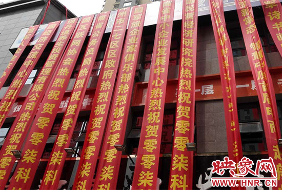 路邊一棟樓上懸掛著二三十條紅色條幅，全部是祝賀一家公司開業(yè)的。