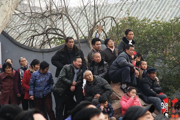 人民公園演出現(xiàn)場擠滿了觀眾，圖為觀眾爬上假山山頭