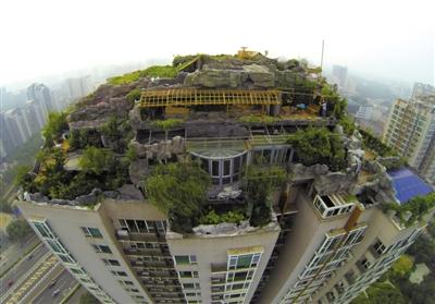 　　昨日，身穿橘黃色馬甲的工作人員在人濟(jì)山莊樓頂拆除違章建筑。新京報(bào)記者 吳江 攝