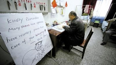 張大爺在門衛(wèi)室里工作，旁邊是紅爆網(wǎng)絡(luò)的溫馨提示牌記者