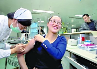 昨日，向雪敏在同濟醫(yī)院血液科病房打動員劑，丈夫陳武右在身后注視著妻子 記者傅克強