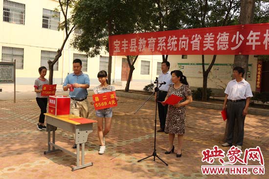 寶豐縣教育系統(tǒng)全體人員在石橋鎮(zhèn)中學(xué)為“美德少年”楊冠明同學(xué)捐款。