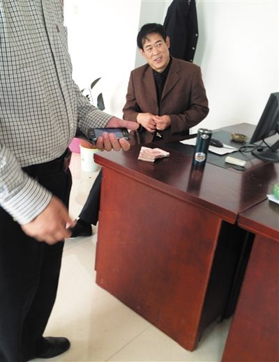10月29日，獻(xiàn)縣國(guó)稅局稽查局辦公室內(nèi)，一名企業(yè)主交了兩萬(wàn)元現(xiàn)金在桌上。新京報(bào)記者 孟祥超 攝
