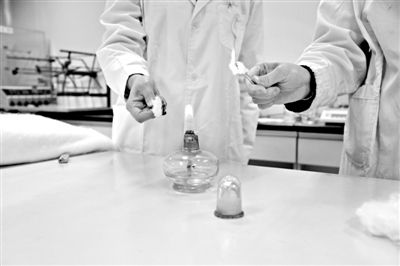 實驗人員操作的燃燒檢測法中，真蠶絲離開火焰就熄滅(左)。