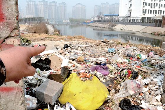金水河長江路橋下河水發(fā)臭，水邊堆放眾多垃圾