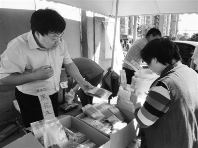 昨日，河南企業(yè)家劉春喜在京“練攤”，為顧客挑選綠豆。新京報記者 張玉學 攝