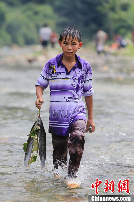 圖為7月9日，一名男孩在鬧魚(yú)節(jié)活動(dòng)中抓到了兩條魚(yú)。譚凱興 攝