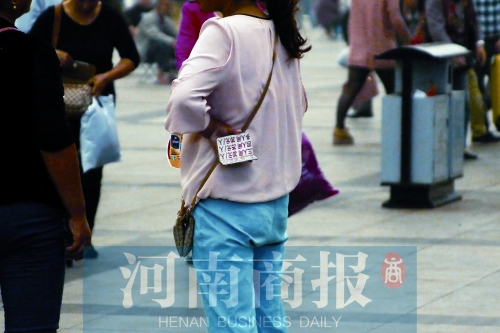 火車站廣場(chǎng)，一女子拿著寫有不同房型價(jià)位的卡片在拉客，不少市民抱怨，受過(guò)此類“騷擾”