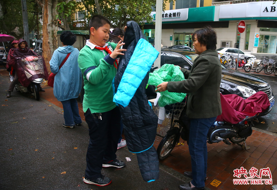 學(xué)校門口，家長給孩子帶來了御寒的厚衣服。