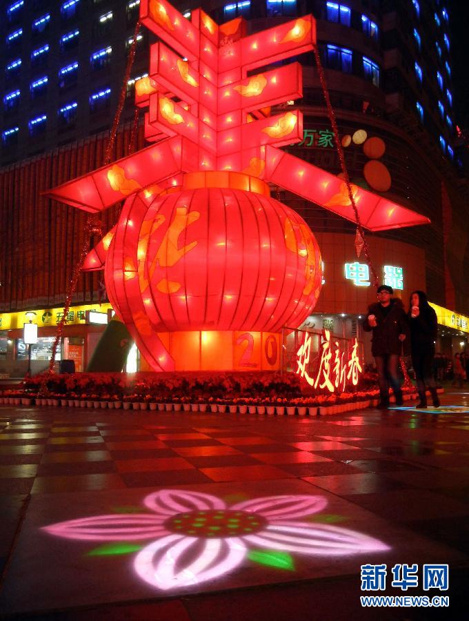 　1月30日晚，市民從蘇州市石路銀河廣場上大型“春”字彩燈景觀旁經(jīng)過。