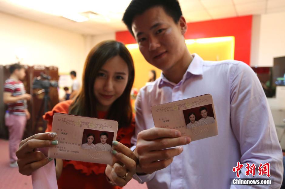 5月20日,河南鄭州,一對準(zhǔn)新人領(lǐng)完結(jié)婚證后秀自拍。