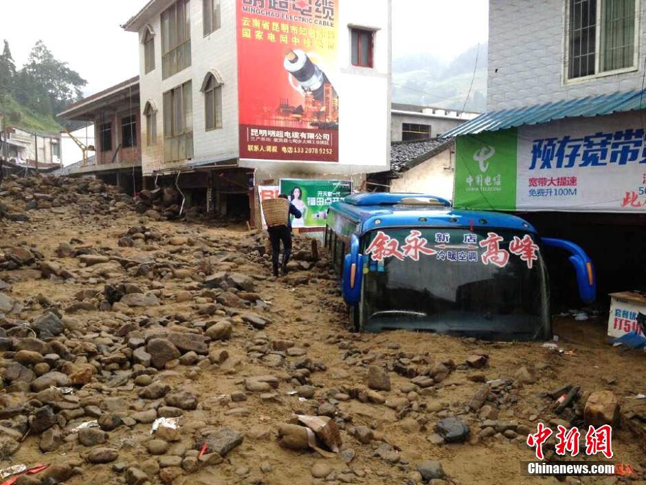 圖為山洪泥石流導(dǎo)沖進鄉(xiāng)鎮(zhèn)街道，導(dǎo)致客車被埋。