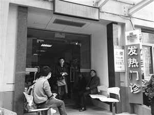 到浙大一院發(fā)熱門診就診的病人增多，不少人在門口等候