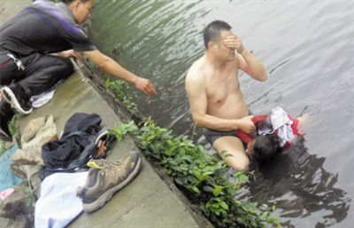 網(wǎng)友貼出民警張光聰一出河水就睜不開眼，用手抹去臉上臟水的照片。