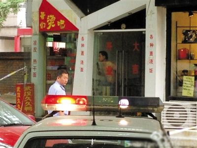 闖入面館的持刀男子與趕來的民警隔著玻璃門對峙，后店內(nèi)一名女童被其劫持。網(wǎng)友供圖