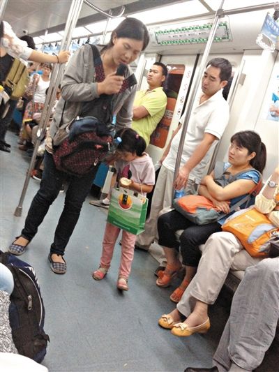 6月27日，舒馨帶一女孩在地鐵十號線行乞。她因被疑帶多個不同小孩乞討被警方搜尋。新京報記者 申志民 攝