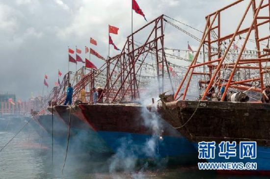 2013年8月1日 南海開漁日 臨高迎新港 8月1日，海南省臨高縣漁民在船上鳴放鞭炮慶祝武蓮港開港。