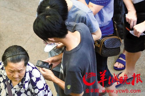 排隊(duì)的“黃?！备魇謭?zhí)一疊白紙，上面寫好了要掛號(hào)的人的信息，包括姓名、電話、要掛的科室等。穿黑白花紋衣服的老婆婆正在排隊(duì)掛號(hào)