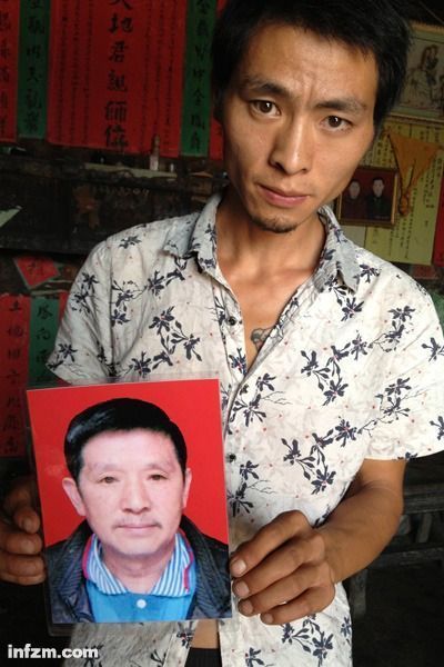 程興貴的兒子程正鵬拿著父親的遺照。程興貴自殺后，政府補償程家6000多塊錢，并終于認定了程興貴的代課教齡。 (南方周末記者雷磊/圖)