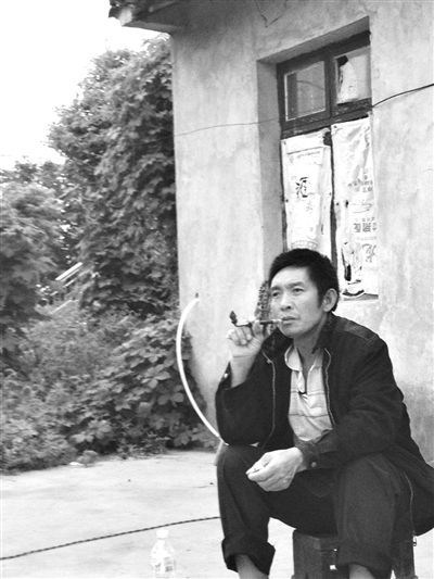 9月12日，陳文才在自己的出租屋旁抽煙。新京報(bào)記者 朱柳笛 攝