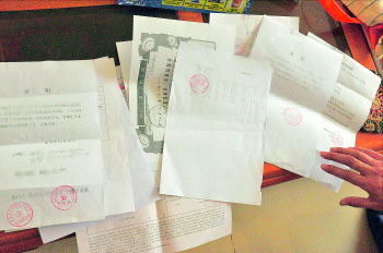 60歲的市民仇先生為了辦理公證所需的這些證明材料,半個月時間里跑了30多趟腿。記者　李萌博　攝