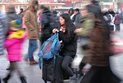 春運(yùn)首日，北京站客流量明顯增多，一名女孩在人流中等待進(jìn)站。