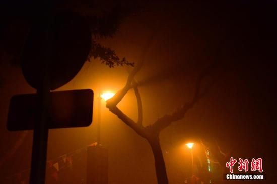 1月31日凌晨，市民行走在煙霧繚繞的南京街頭。當(dāng)天是農(nóng)歷馬年正月初一，南京有限開禁燃放煙花爆竹正逢下霧天，空氣的不流通致使煙花爆竹燃燒后產(chǎn)生的顆粒物不能及時(shí)散開，造成整座城市煙霧繚繞。據(jù)當(dāng)?shù)丨h(huán)保部門發(fā)布的信息顯示，空氣質(zhì)量屬重度污染。中新社發(fā) 泱波 攝