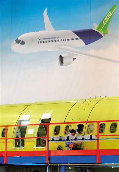 昨日，中國商飛總裝制造中心技術(shù)人員對(duì)接C919首架機(jī)的機(jī)體。新華社記者 丁汀 攝