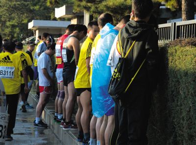 2013年10月20日，北京馬拉松比賽，由于廁位有限，一些選手在綠化帶“就地解決”。圖/IC