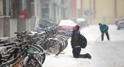 小伙子跪在樓前，一直抬頭看著樓上。 孫立國(guó)/攝
