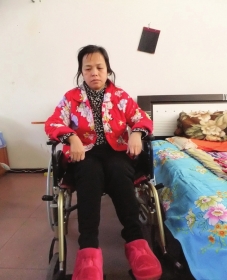 陳慶霞坐在輪椅上。她現(xiàn)在下身癱瘓，疾病纏身，生活不能自理。