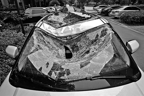 越野車車蓋以及前擋風(fēng)玻璃被砸得凹陷進(jìn)去。見習(xí)記者姚卡/攝