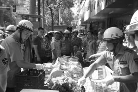 7月11日，瀏陽市北正中路，執(zhí)法人員暫扣張海的水果。這是瀏陽市城管局拍攝的執(zhí)法現(xiàn)場圖。