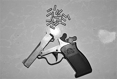 警方從搶劫嫌疑人處起獲的贓款和發(fā)令槍、子彈。警方供圖