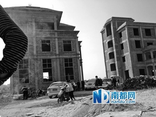兩棟被舉報(bào)的違建樓下昨日一度聚集了超過百人，城管離開后逐漸散去。南都記者張志韜實(shí)習(xí)生宋超攝