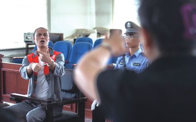 張志國(guó)在法庭上用手語(yǔ)回答提問(wèn)。記者 蒲東峰攝