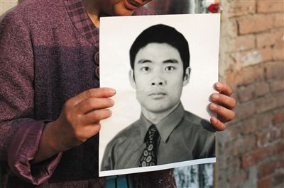 5月19日，朝陽(yáng)北路，母親捧著張東文的遺像。新京報(bào)記者 侯少卿 攝