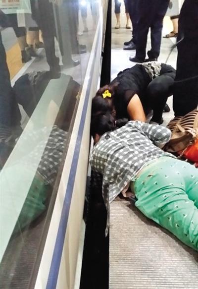 一女子趴在站臺(tái)上，救跌入列車和站臺(tái)間隙的男童。網(wǎng)友璀璨的星月夜 攝