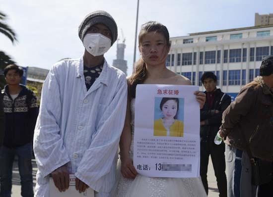 昆明火車站廣場(chǎng)上，24歲的黃習(xí)菊身穿潔白的婚紗，帶著身患白血病的弟弟征婚。