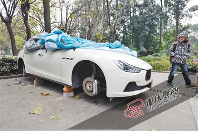 昨日，停放在重慶大學(xué)B區(qū)的一輛瑪莎拉蒂豪車被架在幾塊磚頭上，車輪不翼而飛。 重慶晨報記者 胡杰 攝