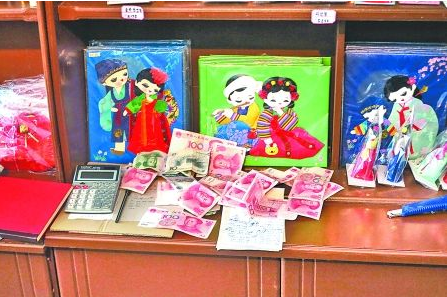 　　2012年6月21日，在朝鮮羅先特別市的一家商店里，柜臺上散落著一些人民幣。在朝鮮，人民幣比本國