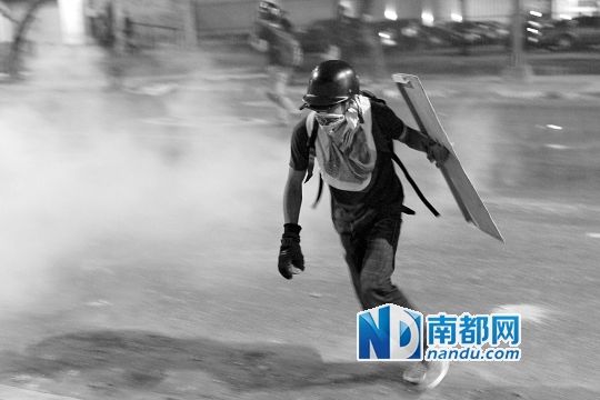 反政府示威者在與警察的沖突中躲避催淚彈。