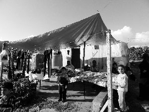 黎巴嫩一敘利亞難民營(yíng)，難民支起攤鋪賣衣服掙錢。