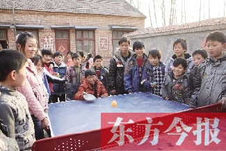 坐著輪椅的小宗成和同學(xué)們一塊打乒乓球，這是他感到最快樂的事