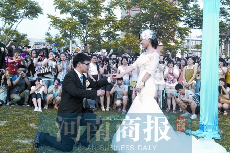 在學校操場的草坪上，兩名畢業(yè)生舉行婚禮，有同學感動地抹起眼淚