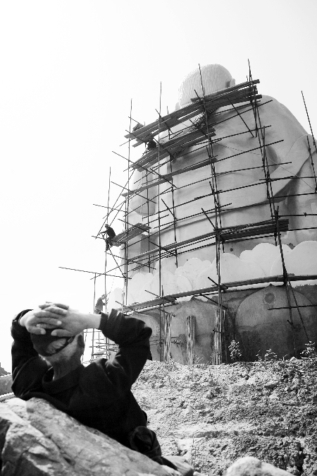 今年4月26日，工作人員將帆布蓋在“佛像”頭像上