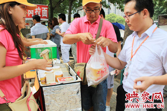 圖為徐貴雨和一名勤工助學(xué)的學(xué)生在街頭義賣快餐。