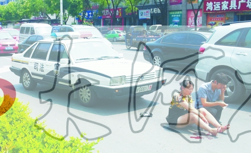 事故發(fā)生后，警車司機(jī)（右）下車查看傷者并撥打120，倆“領(lǐng)導(dǎo)”穩(wěn)坐車內(nèi)引發(fā)圍觀者不滿。